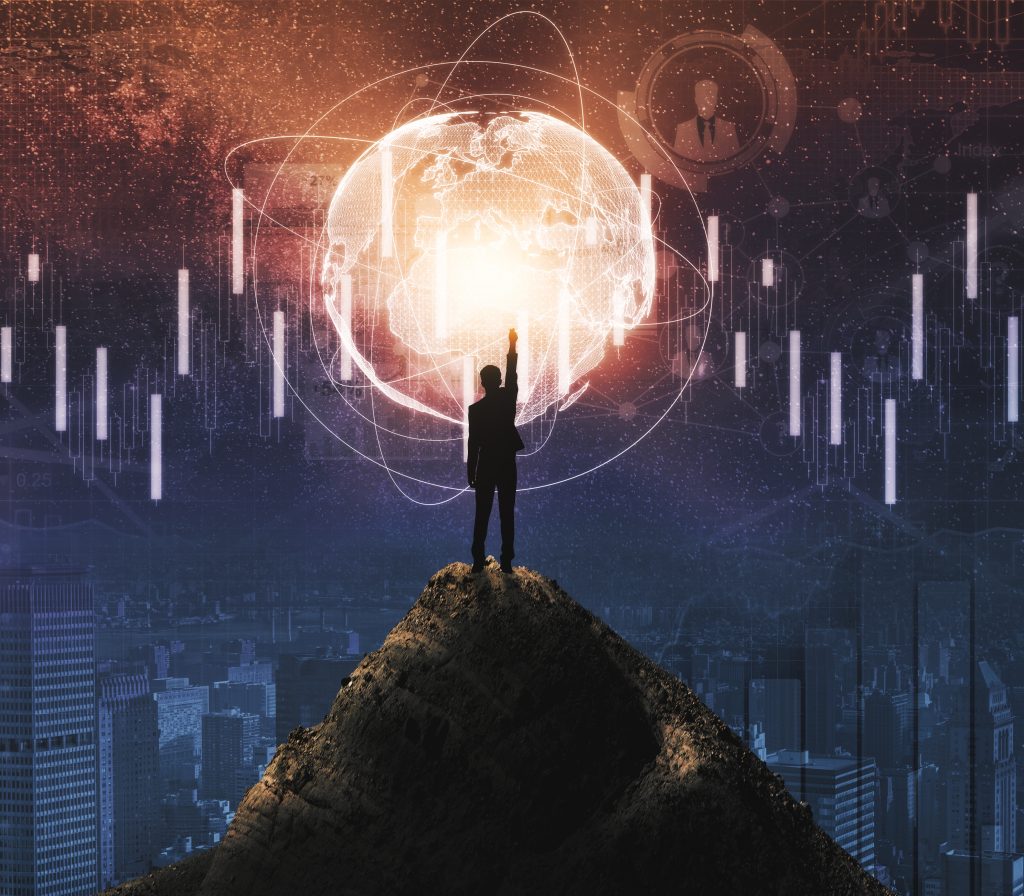 Businessman on a mountain top pointing toward future goals