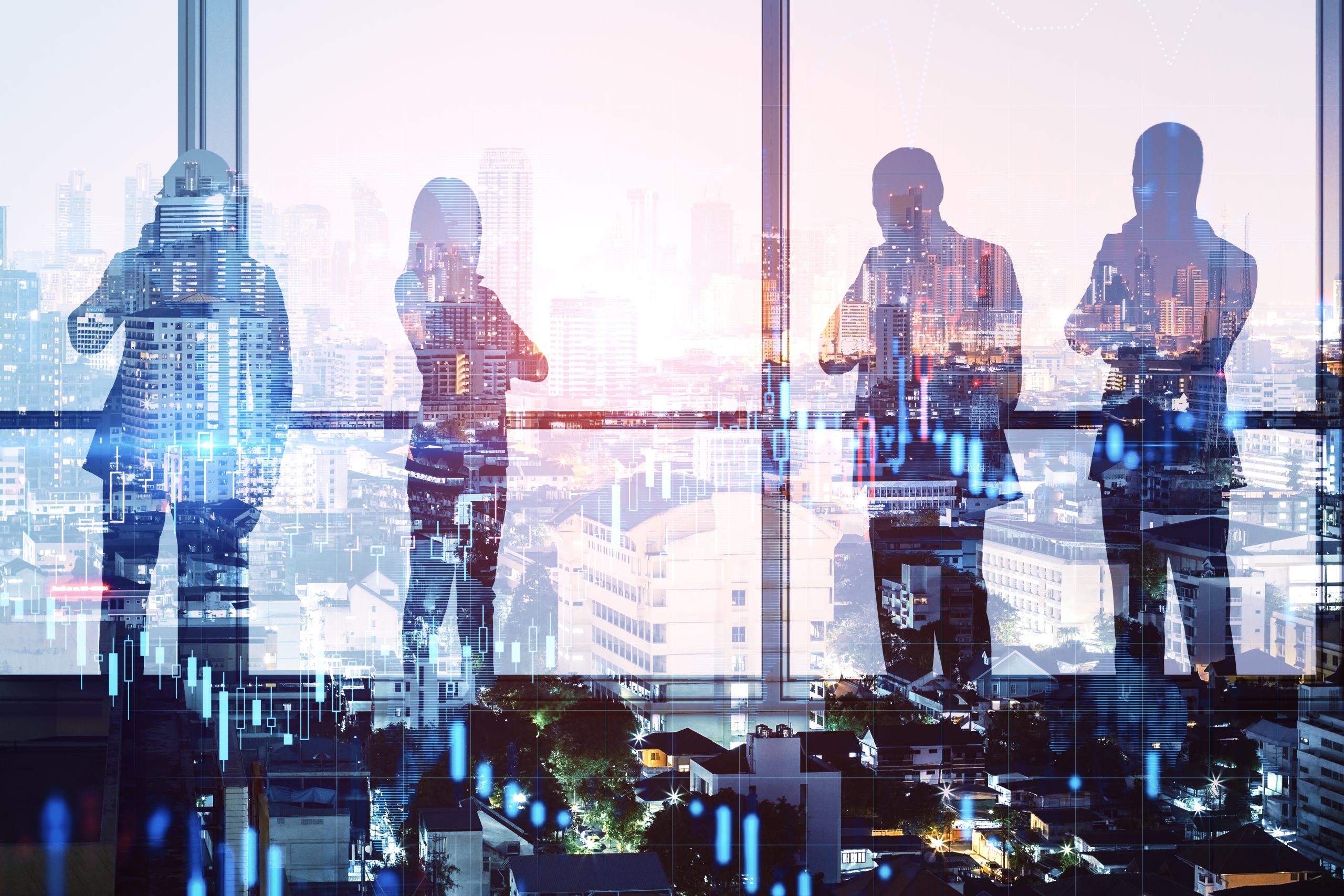 Business colleagues standing together against an illuminated city skyline
