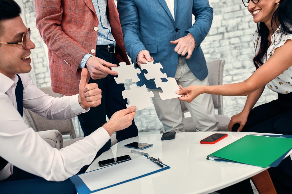 Business people joining puzzle pieces representing collaboration