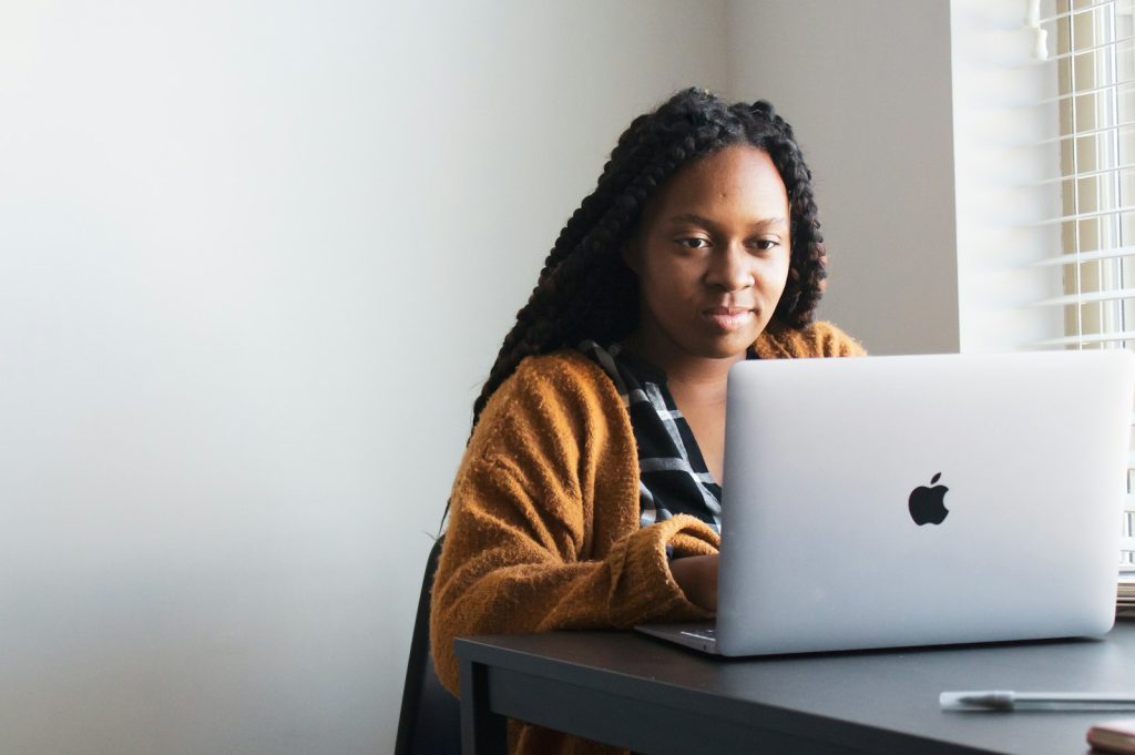 Small business owner using AI for small business admin on a laptop in a workshop office