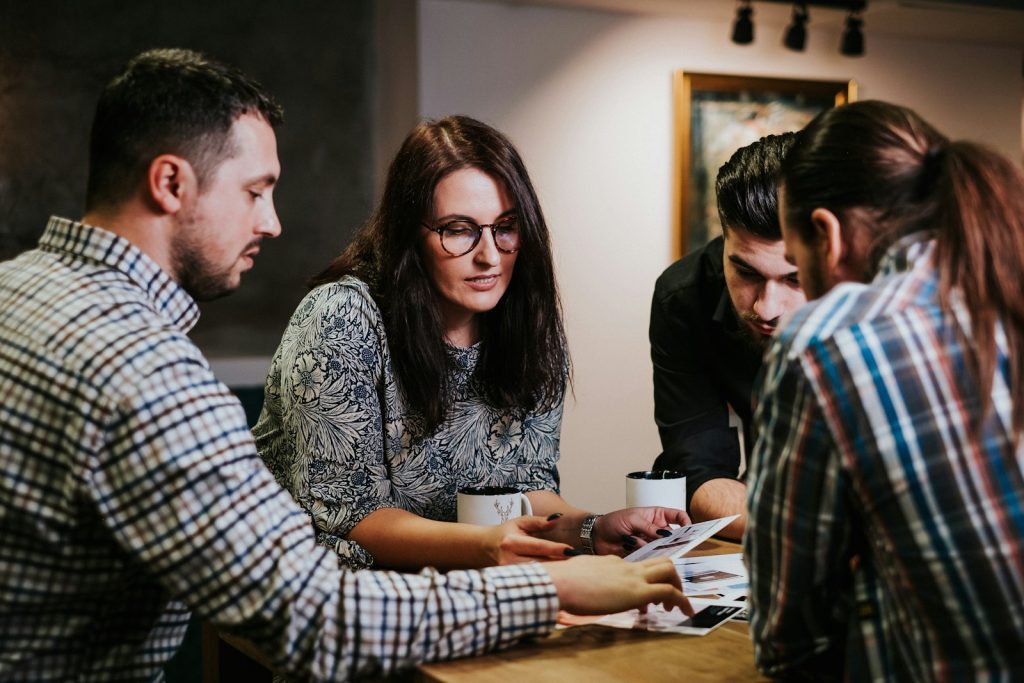 Management team comparing conflicting reports in a meeting, a common sign of data silos